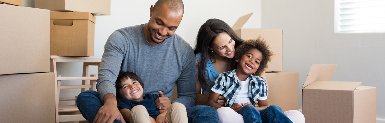 Family sitting on floor surrounded by boxes