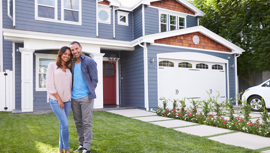 Couple standing in front of new home