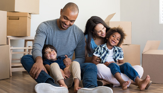 Family sitting on floor surrounded by boxes