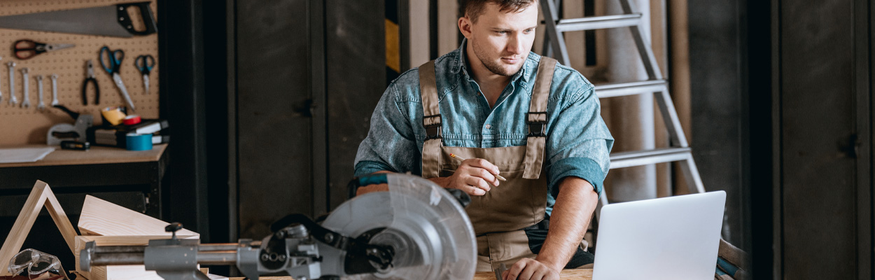 Small Business Owner in Workshop on Laptop