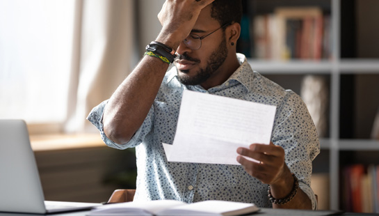 Man looking stressed over papers