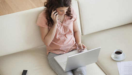 Woman on the phone looking at laptop