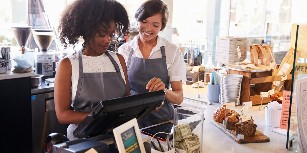 business owner and employee at cash register