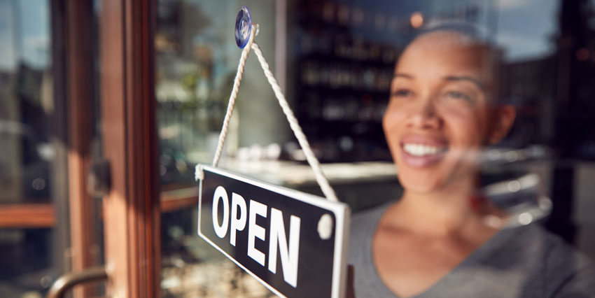 business owner turning open sign