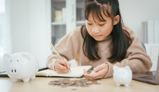 a-girl-sits-at-a-table-saving-money-web